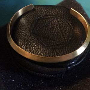 Gold cuff bracelet with black storage case